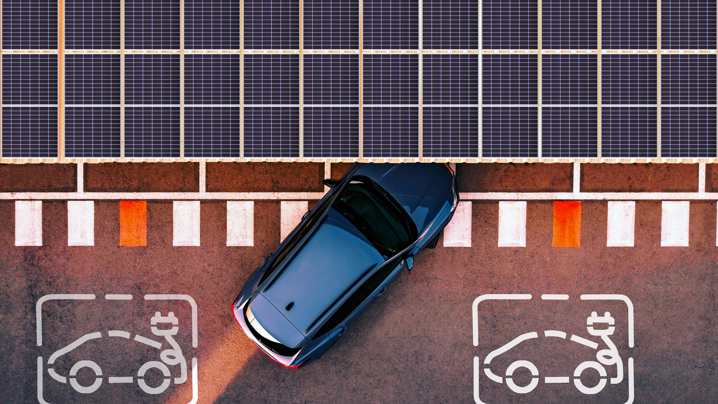 Aerial view of electric car parking in charging station with solar panels.