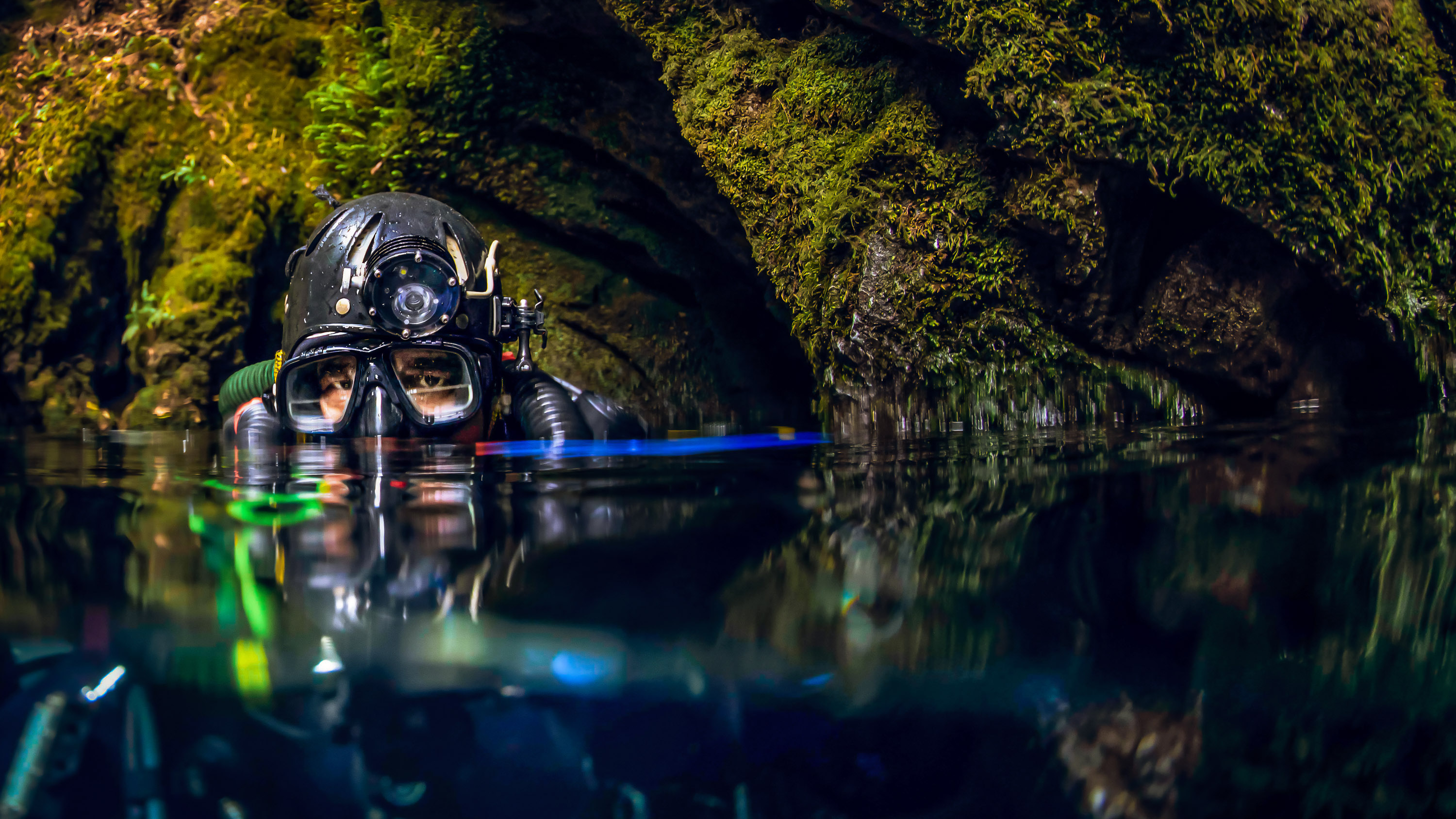 the top of a diver's head just above the waterline in a cave