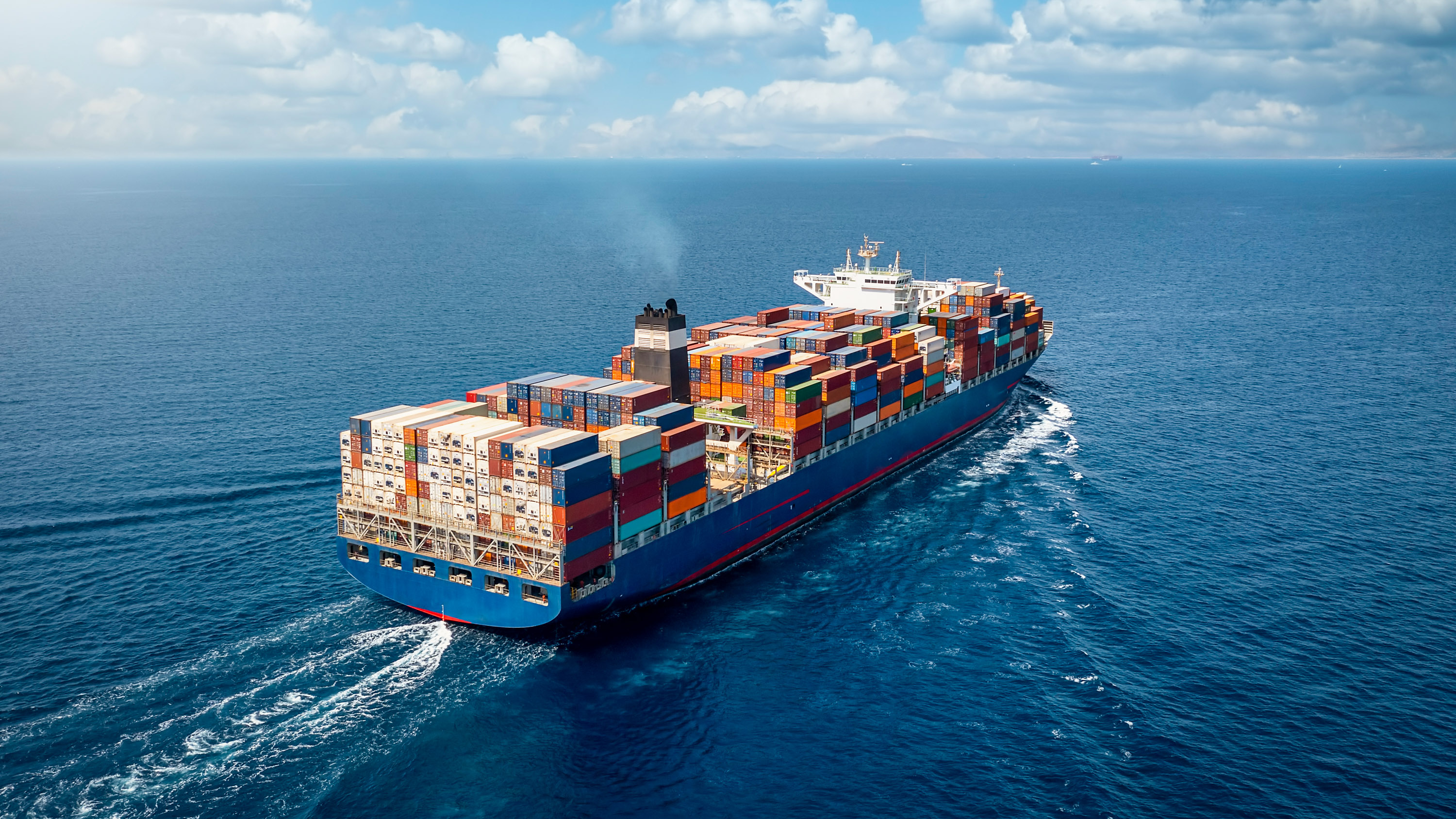 A large container cargo ship travels over the ocean